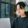 Student wearing headphones staring at a laptop screen